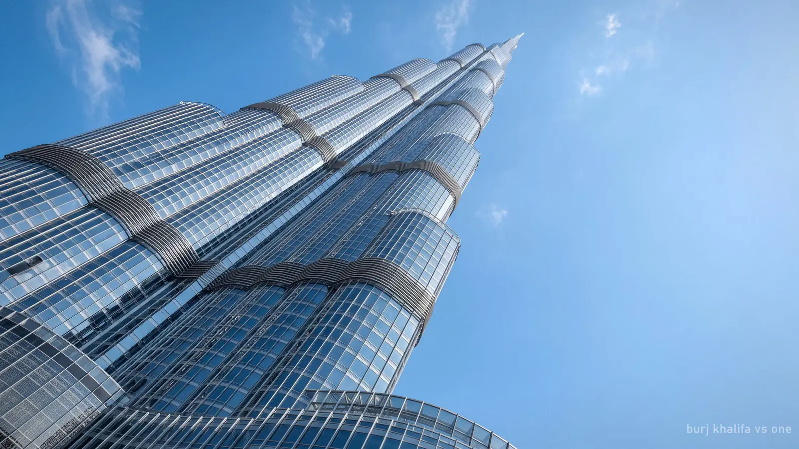 The Burj Khalifa's glass and steel facade in sharp midday light, close-up looking up (generated illustration)